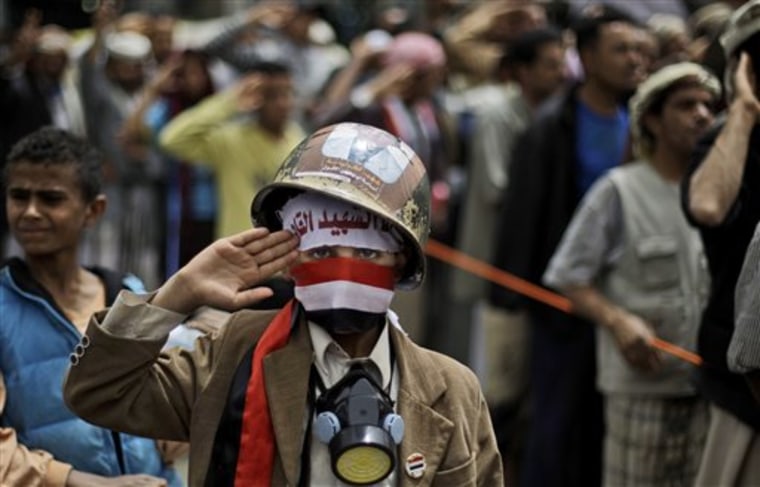 A Yemeni boy, wearing a helmet and a gas mask, salutes  along with anti-government protesters during a demonstration demanding the resignation of Yemeni President Ali Abdullah Saleh, in Sanaa,Yemen, on Sunday. 